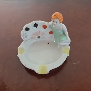 Vintage porcelain ashtray with figural "Trump Indicator Girl" and card suits